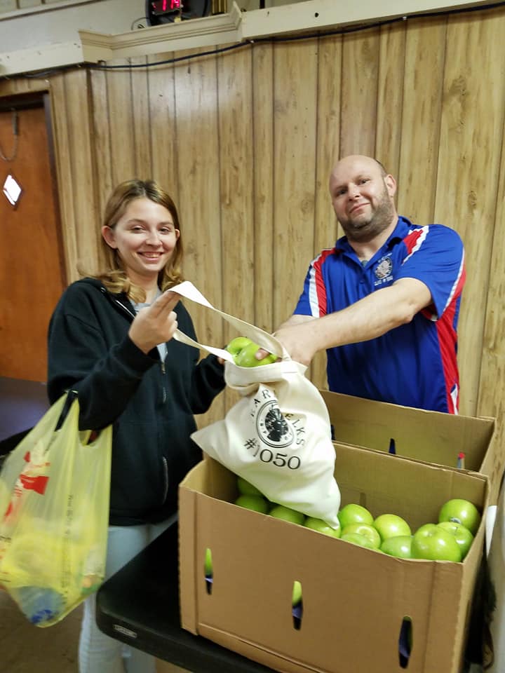 ER Chris Pasquarelli is happy to help one of our residents with some fruit at one of our annual Health Fairs.