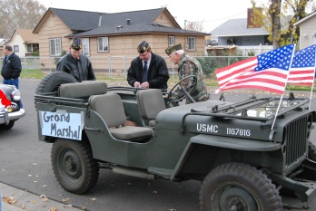 r-l Elk and VFW members John Ehart drives his vintage era jeep in the Veteran's Day parade. Getting attention of Alan Richardson VFW Commander and Andy Millar.