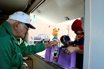 Long time member Ed Rand hands out candy to trick-or-treaters with Casey Elk in the background.