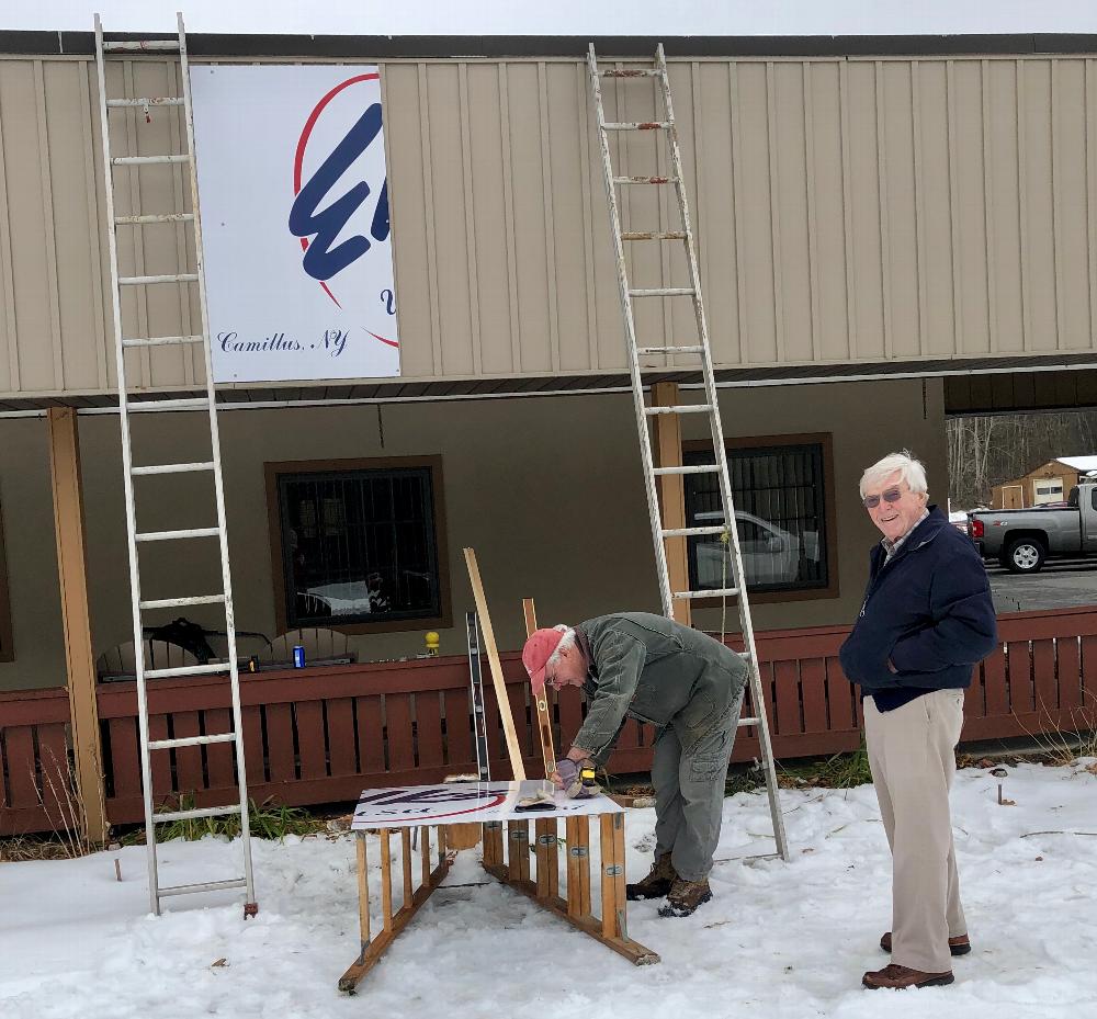 Rick Lopez works hard to place new Elks lodge sign on the building while Red Flaherty assists. This sign was compliments of Good Member Lenny Sherwood. 2019