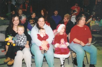 Youngers and parents eagerly await their turn ro receive gifts from Santa at the 2007 Elks Children's Christmas party. Pictured (left to right) are Alicia Clark and her son, Dietric; Tiffany LeClair, holding her daughter, Saige; Hailey LeClair, Tiffany's oldest daughter; and Cheryl LeClair, Tiffany's mom.