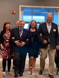 2020-21 President-Elect Bob and Beth Colie being escorted by Mary & Chuck Burke 